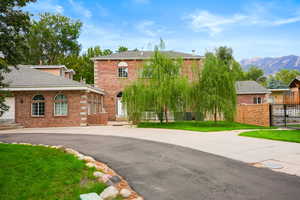 View of front of home with brick siding, a mountain view, and driveway