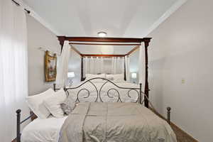 Bedroom featuring ornamental molding and carpet floors