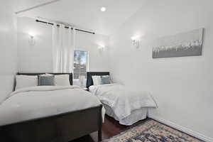 Bedroom with wood finished floors, recessed lighting, and vaulted ceiling