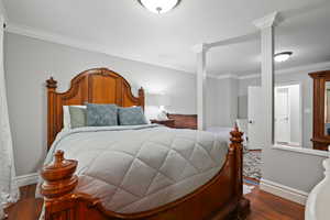 Bedroom featuring wood finished floors and ornamental molding