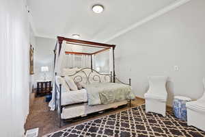 Carpeted bedroom with ornamental molding