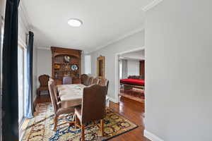 Dining area featuring hardwood / wood-style flooring and ornamental molding