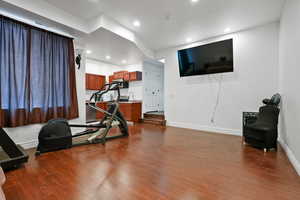 Exercise area featuring dark wood-style floors and recessed lighting