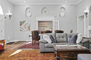 Living room featuring ornamental molding, wood finished floors, and recessed lighting