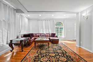 Living room with light wood-type flooring and recessed lighting