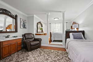 Bedroom with wood finished floors and crown molding