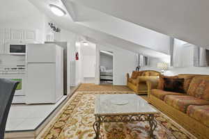 Living room with lofted ceiling and light tile patterned floors
