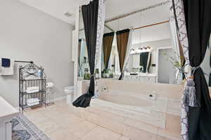 Bathroom with a garden tub, vanity, light tile patterned floors, and a textured ceiling