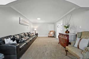 Living area with crown molding, carpet floors, and arched walkways