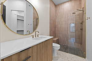 Bathroom featuring vanity, walk in shower, and light tile patterned floors