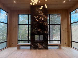 Detailed view of recessed lighting, wooden ceiling, wood finished floors, a multi sided fireplace, and wooden walls