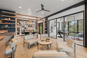 Living area with light wood-style floors, a ceiling fan, and plenty of natural light