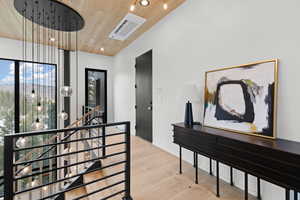 Hallway featuring wooden ceiling, light wood-type flooring, recessed lighting, an upstairs landing, and cooling unit