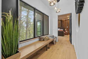 Hallway with light wood finished floors and a chandelier