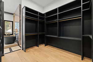 Walk in closet featuring light wood-style flooring