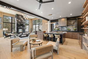 Living area with light wood-style flooring, ceiling fan, wood walls, and rail lighting