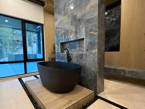 Bathroom featuring a soaking tub and tile walls