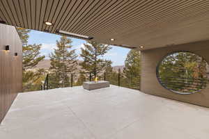 View of patio with a mountain view and an outdoor fire pit