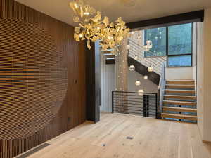 Formal dining room with hardwood / wood-style flooring, stairs, and a chandelier
