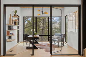 Office area with wood finished floors, healthy amount of natural light, and suspended lighting