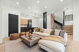 Living room with light wood-style flooring and recessed lighting