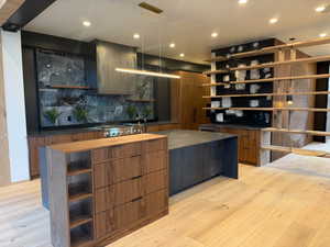 Kitchen featuring open shelves, modern cabinets, backsplash, light wood-style flooring, and recessed lighting