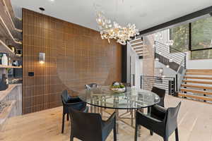 Dining area with light wood finished floors and hanging lights