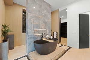 Bathroom with a freestanding bath, a spacious closet, and recessed lighting