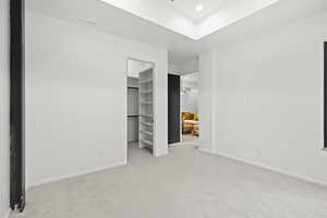 Unfurnished bedroom featuring light carpet, a spacious closet, and recessed lighting