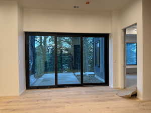 Doorway with hardwood / wood-style flooring and baseboards