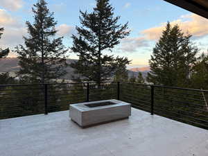 Patio terrace at dusk with a patio, an outdoor fire pit, and a mountain view