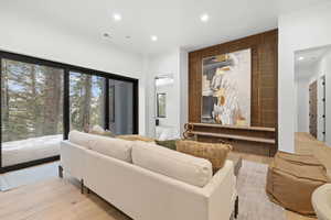 Living area with light wood-type flooring, recessed lighting, and a sauna
