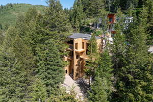 Aerial view of property and surrounding area with a forest