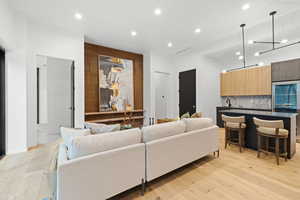 Living room with light wood-style flooring and recessed lighting