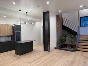Kitchen featuring dark countertops, recessed lighting, modern cabinets, a center island, and light wood-style flooring