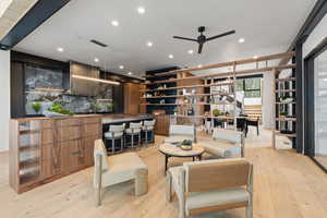Living area featuring light wood-style floors, a ceiling fan, and recessed lighting