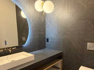 Bathroom with vanity, light wood-style floors, and tile walls