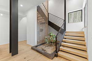Stairway featuring hardwood / wood-style floors and recessed lighting