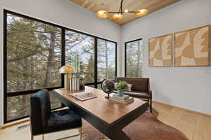 Home office featuring light wood-type flooring, wooden ceiling, and a chandelier