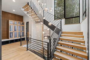 Staircase featuring hardwood / wood-style floors, recessed lighting, and a high ceiling