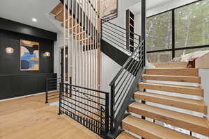 Staircase with hardwood / wood-style floors and recessed lighting