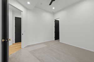 Spare room featuring light colored carpet, a ceiling fan, and recessed lighting