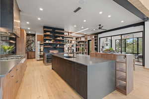 Kitchen with modern cabinets, dark stone countertops, and hanging light fixtures
