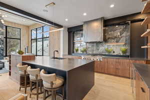 Kitchen featuring modern cabinets, a kitchen breakfast bar, light wood-type flooring, and plenty of natural light