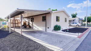 View of front of home with a shed, a carport, crawl space, and driveway