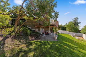 Rear view of property featuring a deck, a patio area, and a fenced backyard
