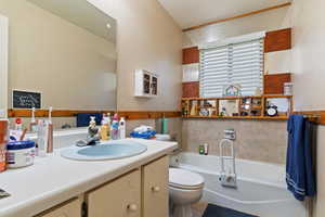 Bathroom with a garden tub, vanity, a textured ceiling, and a textured wall