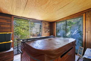 Miscellaneous room featuring a jacuzzi, wooden walls, and wooden ceiling