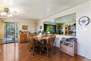 Dining space featuring wood finished floors, a textured ceiling, and ceiling fan