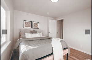 Bedroom with wood finished floors and baseboards